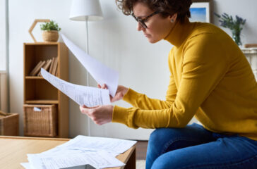 Concentrated woman reviewing financial documents at home