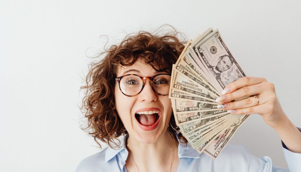 happy woman in blue long sleeve blouse holding money